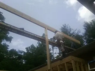 Carpenter setting a ridge beam over a new addition frame — Ice Dam Removal by Roofing Brothers in Minocqua