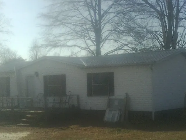 New metal roof on a white painted brick home on a foggy morning in Minocqua