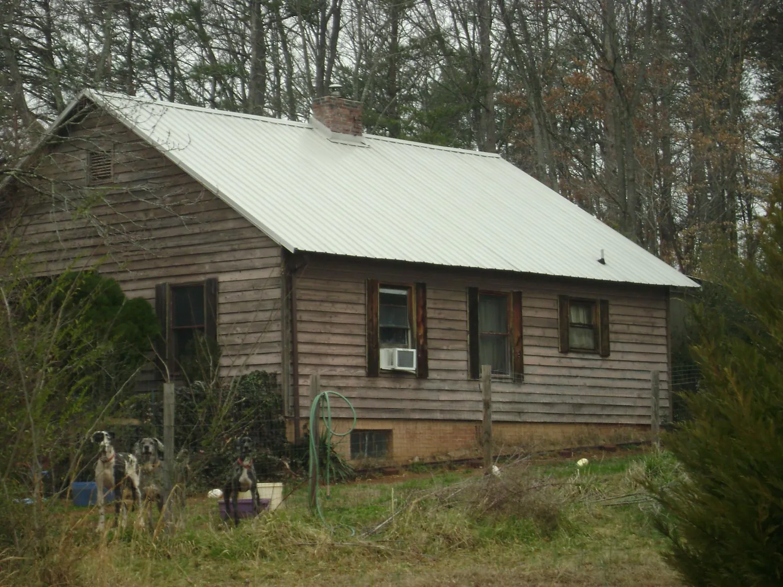 White metal roof on an old wood sided farmhouse, from a Metal Roof Installation job in Minocqua